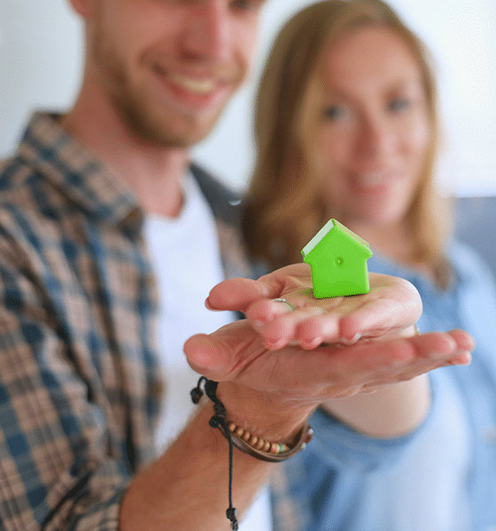 Man en vrouw met een speelgoedhuisje in handen.