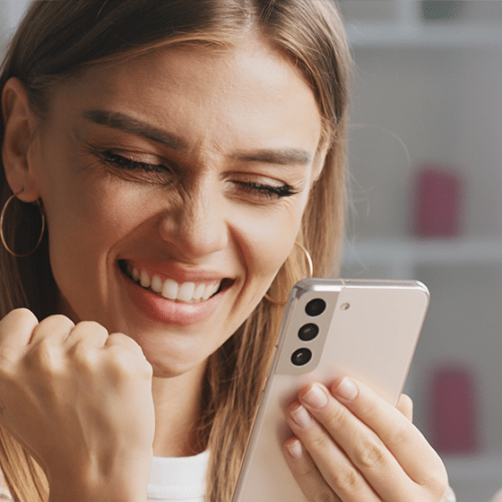 Iemand die vrolijk naar haar telefoon kijkt